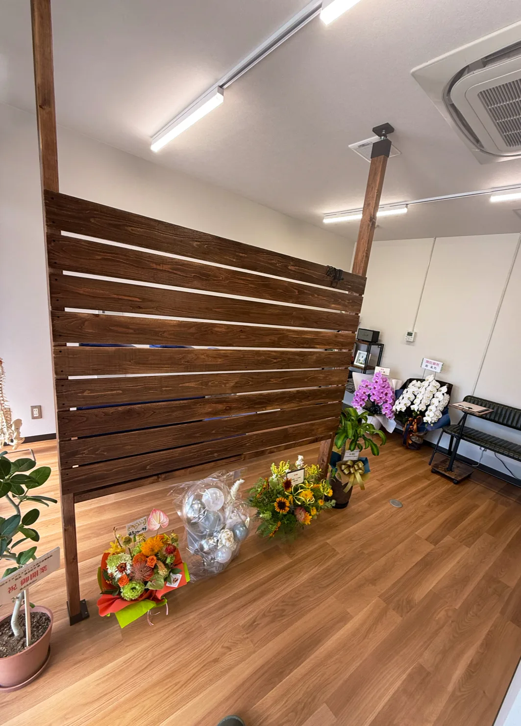 木の間仕切りと待合のベンチがある院内